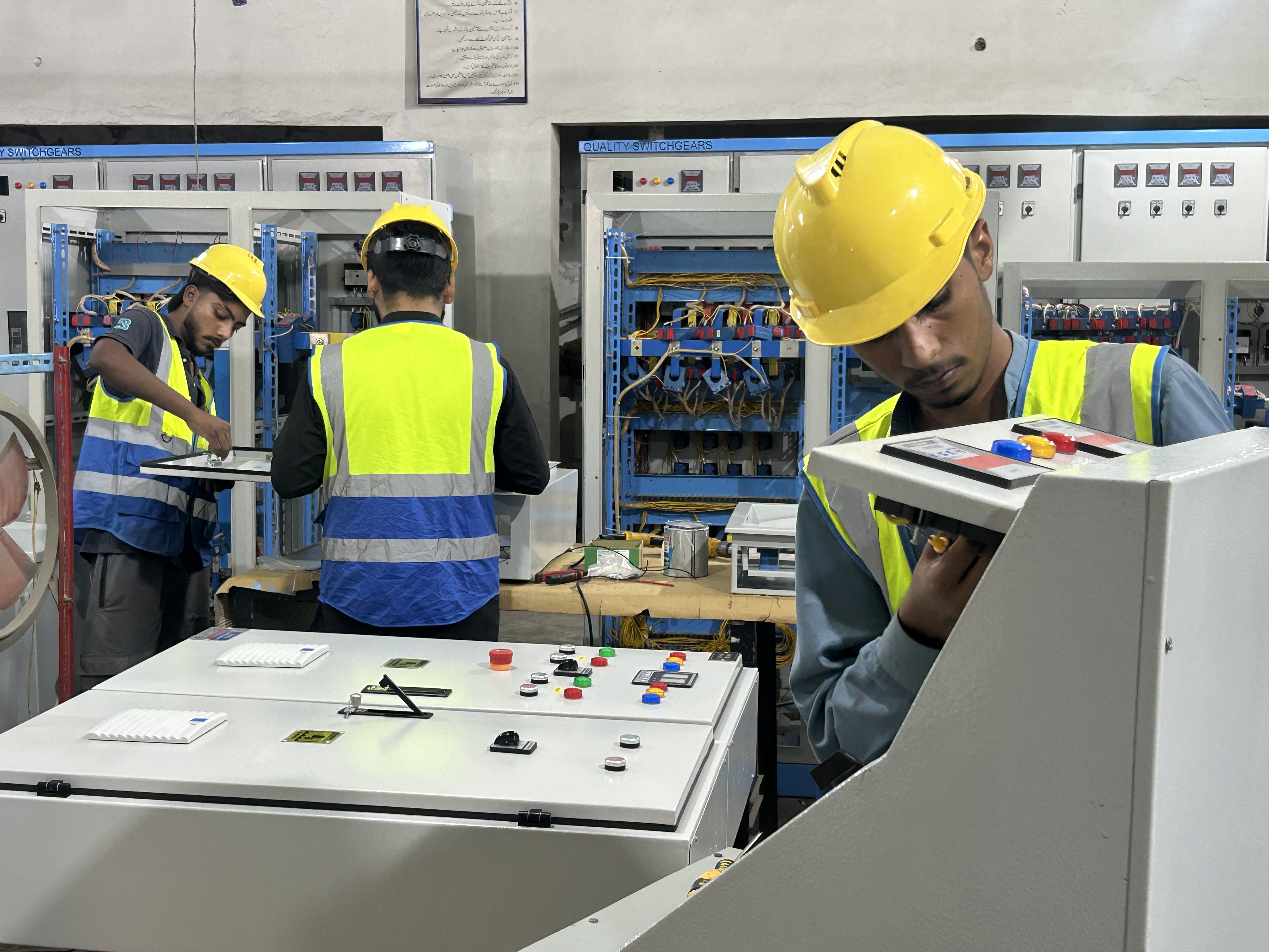 Technicians assembling control panels on the factory floor