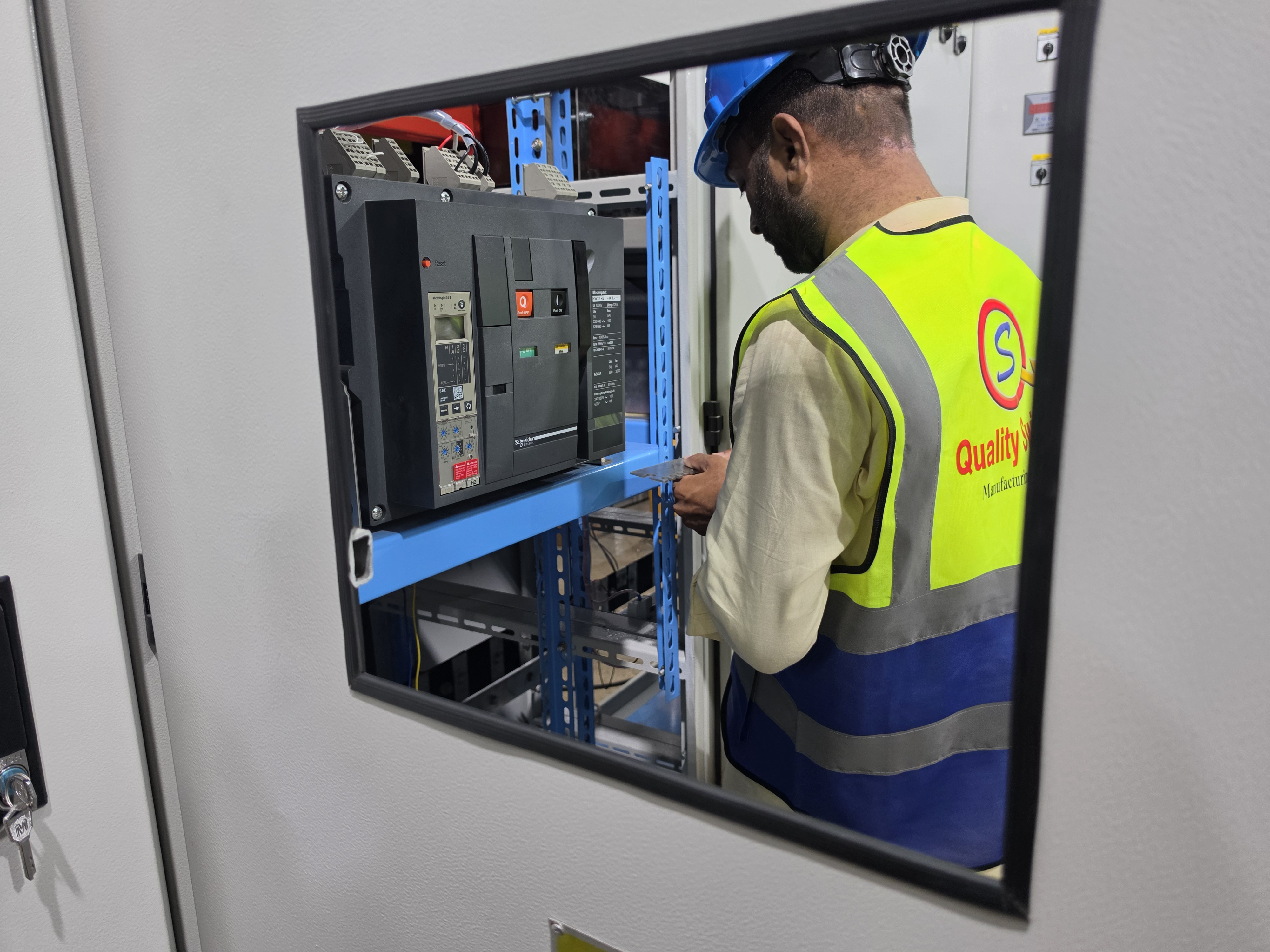 Inspector verifying a circuit breaker inside a switchgear enclosure